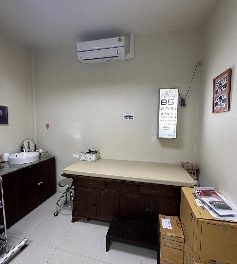 ห้องตรวจของเพชรบูรณ์คลินิก มีเตียงตรวจและแผ่นวัดระดับสายตาติดผนัง
